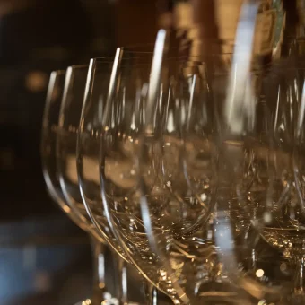 Wine glasses aligned on restaurant bar shelf